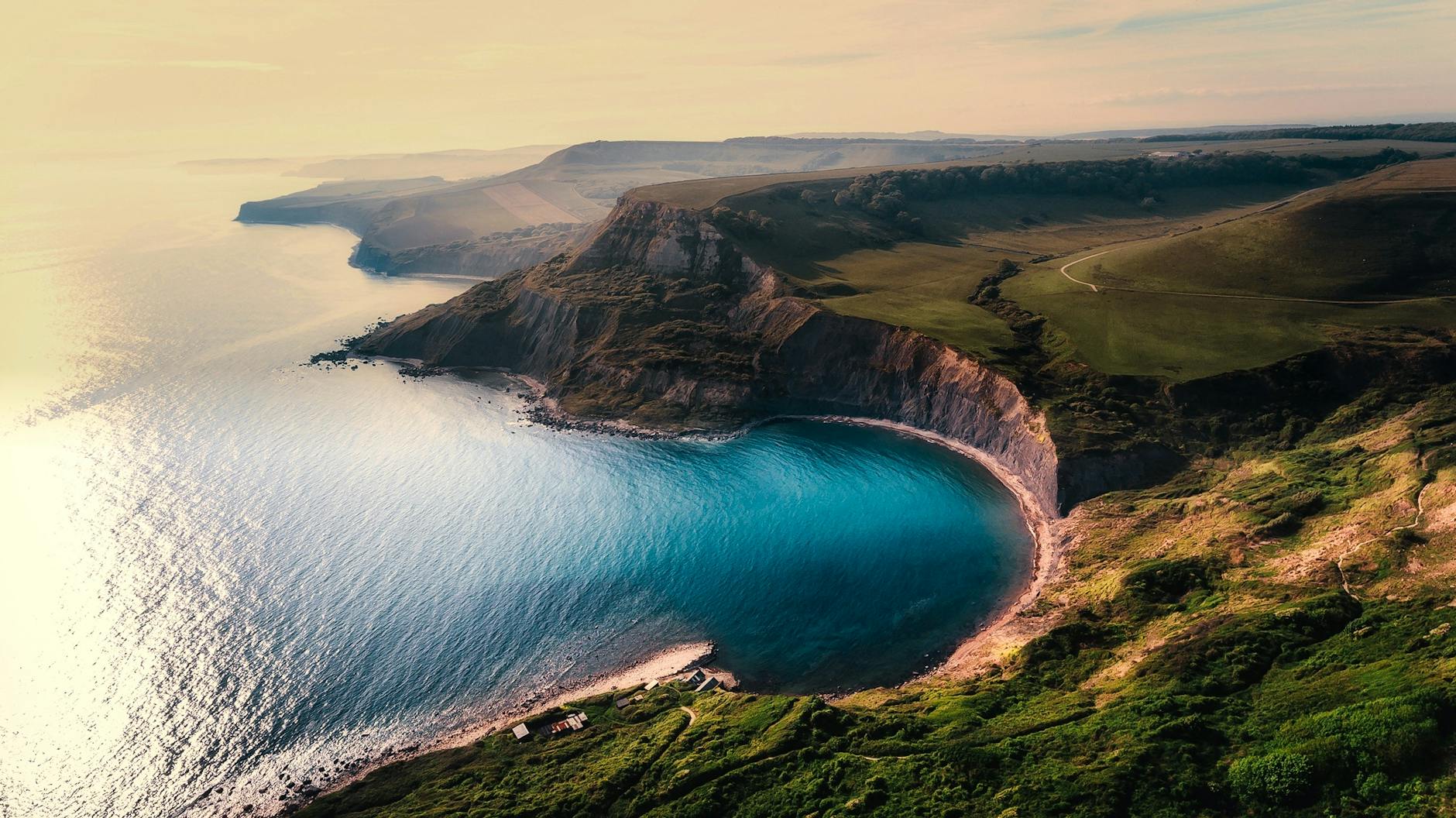 green hill near body of water