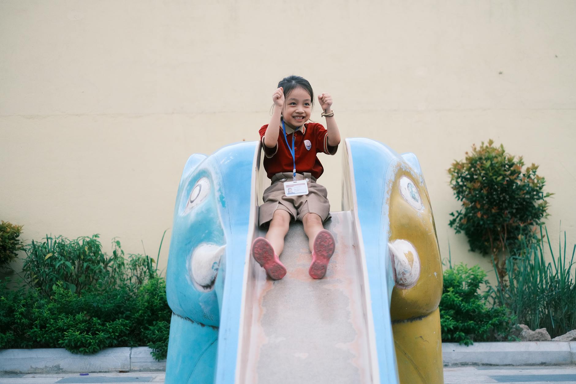 joyful child sliding down playground slide